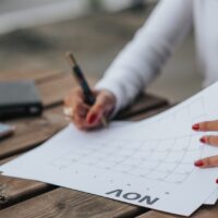 Mulher consultando e fazendo anotações do prazo do contrato de locação em um calendário